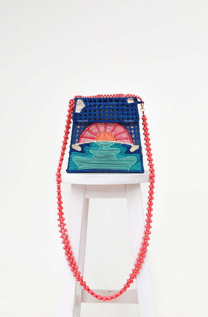 Miss Me HandbagHard Shaped BagHandcrafted handbag with natural raffia fiber. Welded and hand-woven structure in the shape of a sunset by the sea. Inner lining made of natural cotton fabric. Flip GlobalistinaMissGlobalistina