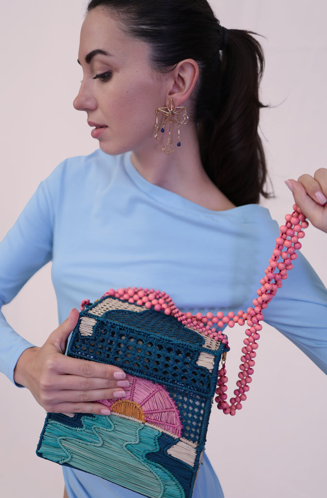 Miss Me HandbagHard Shaped BagHandcrafted handbag with natural raffia fiber. Welded and hand-woven structure in the shape of a sunset by the sea. Inner lining made of natural cotton fabric. Flip GlobalistinaMissGlobalistina