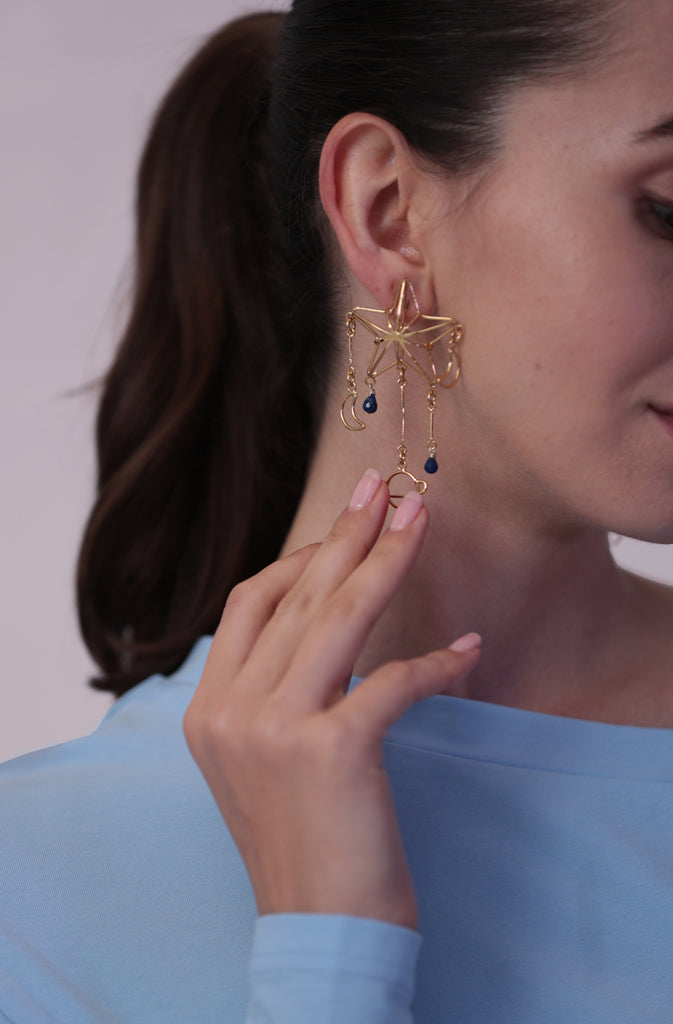 Lapis Star EarringsEarringsExtra light push-back earrings delicately depicting parts of our beautiful solar system, enriched with a splash of colour thanks to the lapis stones in a deep blue. GlobalistinaLapis Star EarringsGlobalistina